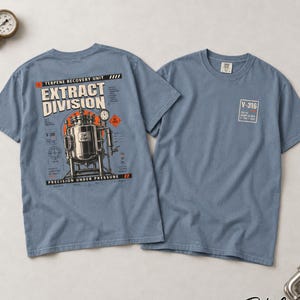 May include: A blue short-sleeve t-shirt featuring a graphic on the back of a metallic industrial extraction tank with the text "TERPENE RECOVERY UNIT," "EXTRACT DIVISION," and "PRECISION UNDER PRESSURE." The front chest has a small square logo with "V-316."