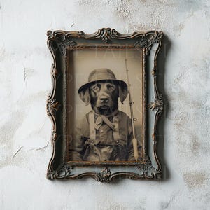 May include: A black Labrador Retriever dressed in a vintage fishing outfit, wearing a brown hat and holding a fishing rod. The photo is framed in a dark brown ornate frame.