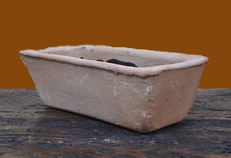 Puede incluir: Un macetero rectangular de terracota con un esmalte marr&oacute;n claro. El macetero est&aacute; vac&iacute;o y tiene una textura ligeramente rugosa.