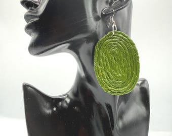May include: An oval-shaped earring featuring a coiled, textured olive green surface. The earring is suspended from a silver-toned metal hook, showcasing a distinct spiral pattern created by the layered material, providing a bold and tactile appearance.