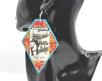 May include: A diamond-shaped dangle earring featuring a vintage Billie Holiday concert poster graphic. The design includes red, yellow, and blue colors with text reading Paradise, April 22, and Andy Kirk and His Band, suspended from a silver-toned hook.