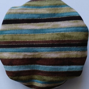 May include: A striped fabric pouch with brown, green, blue, and white stripes. The pouch is made of a soft, textured fabric.
