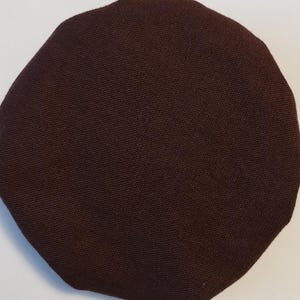 May include: A dark brown fabric circle, possibly a patch or a piece of fabric for a craft project.