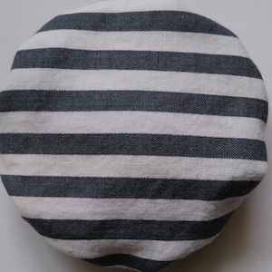 May include: A round, gray and white striped fabric cover. The cover is made of a soft, woven material.