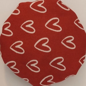 May include: Red fabric with a white heart pattern.