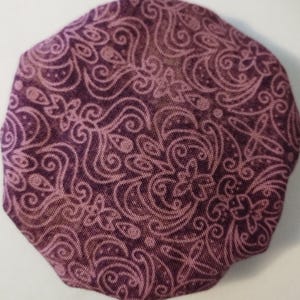 May include: A purple fabric circle with a white paisley pattern.