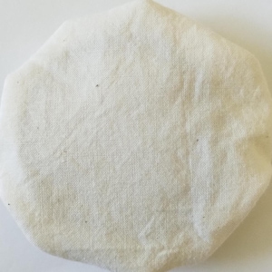 May include: A white cotton round fabric with a slightly textured surface.