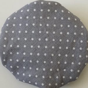 May include: A gray fabric circle with white polka dots.