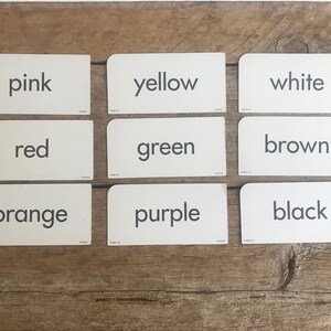 May include: Set of 10 color flashcards with the words "pink", "yellow", "white", "red", "green", "brown", "orange", "purple", "black" printed on them.