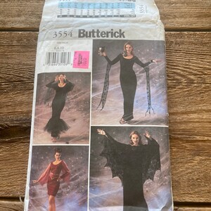 Op de afbeelding: Een naaipatroon voor een heksenkostuum. Het patroon bevat drie verschillende stijlen: een lange zwarte jurk met een cape, een lange zwarte jurk met vleermuisvleugels en een kortere jurk met een cape. Het patroon is van Butterick en het patroonnummer is 3554.
