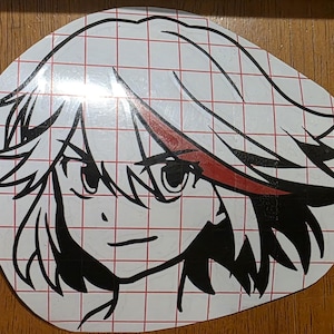 May include: A die-cut sticker featuring a stylized anime character's face. The design is primarily black and white, with red accents on the hair and eyes. The sticker is on a grid-patterned backing.