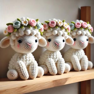 May include: Three white crocheted lambs wearing flower crowns with pink, white, and blue flowers. The lambs are sitting on a wooden shelf.