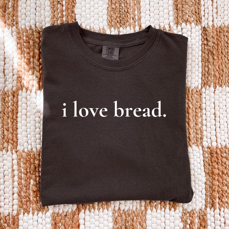 Simple. Honest. Relatable.
This “I Love Bread” Comfort Colors t-shirt is made for anyone who believes bread deserves more appreciation. Featuring clean, minimalist text and a soft, lived-in feel, this tee is the perfect blend of humor and everyday comfort.