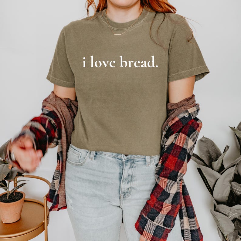 Simple. Honest. Relatable.
This “I Love Bread” Comfort Colors t-shirt is made for anyone who believes bread deserves more appreciation. Featuring clean, minimalist text and a soft, lived-in feel, this tee is the perfect blend of humor and everyday comfort.