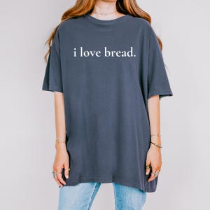 Simple. Honest. Relatable.
This “I Love Bread” Comfort Colors t-shirt is made for anyone who believes bread deserves more appreciation. Featuring clean, minimalist text and a soft, lived-in feel, this tee is the perfect blend of humor and everyday comfort.