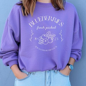 Printed on a soft-washed Comfort Colors 1566 crewneck, this sweatshirt has that lived-in feel right from the first wear. With its relaxed fit and pigment-dyed fabric, it pairs perfectly with your favorite denim, leggings, or cutoff shorts for a cozy-cute summer loo