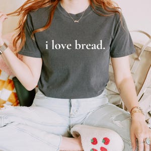 Simple. Honest. Relatable.
This “I Love Bread” Comfort Colors t-shirt is made for anyone who believes bread deserves more appreciation. Featuring clean, minimalist text and a soft, lived-in feel, this tee is the perfect blend of humor and everyday comfort.