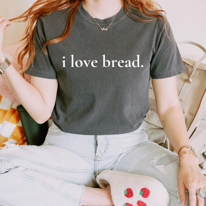 Simple. Honest. Relatable.
This “I Love Bread” Comfort Colors t-shirt is made for anyone who believes bread deserves more appreciation. Featuring clean, minimalist text and a soft, lived-in feel, this tee is the perfect blend of humor and everyday comfort.