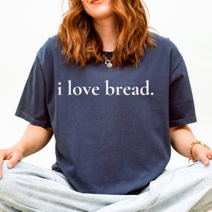 Simple. Honest. Relatable.
This “I Love Bread” Comfort Colors t-shirt is made for anyone who believes bread deserves more appreciation. Featuring clean, minimalist text and a soft, lived-in feel, this tee is the perfect blend of humor and everyday comfort.