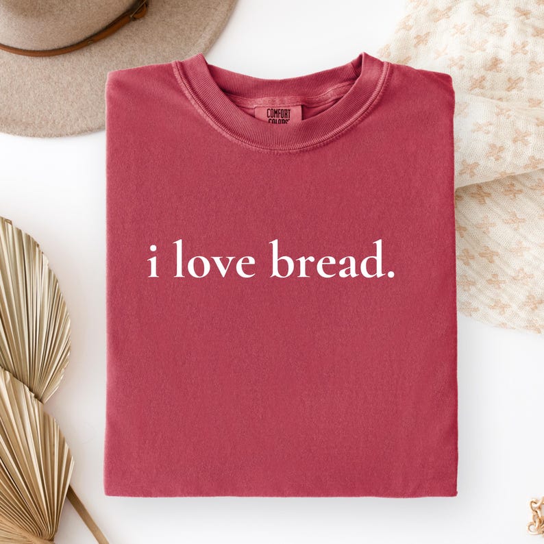 Simple. Honest. Relatable.
This “I Love Bread” Comfort Colors t-shirt is made for anyone who believes bread deserves more appreciation. Featuring clean, minimalist text and a soft, lived-in feel, this tee is the perfect blend of humor and everyday comfort.