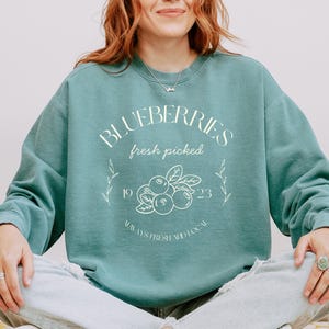 Printed on a soft-washed Comfort Colors 1566 crewneck, this sweatshirt has that lived-in feel right from the first wear. With its relaxed fit and pigment-dyed fabric, it pairs perfectly with your favorite denim, leggings, or cutoff shorts for a cozy-cute summer loo