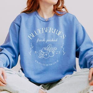 Printed on a soft-washed Comfort Colors 1566 crewneck, this sweatshirt has that lived-in feel right from the first wear. With its relaxed fit and pigment-dyed fabric, it pairs perfectly with your favorite denim, leggings, or cutoff shorts for a cozy-cute summer loo