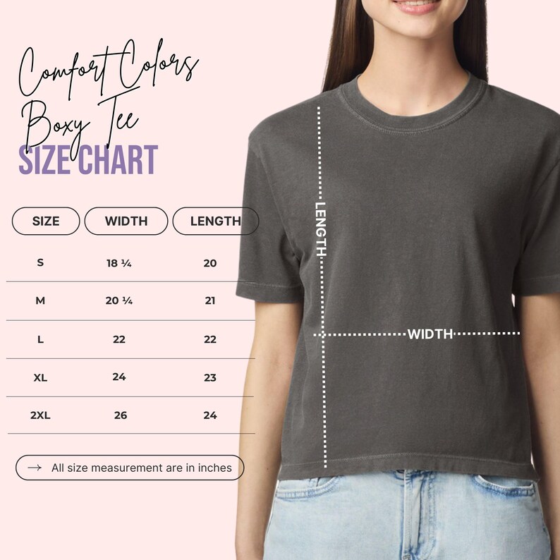 Op de afbeelding: Een donkergrijs Comfort Colors Boxy Tee. De afbeelding bevat een maattabel met afmetingen in centimeters: S (46,36 cm breedte, 50,8 cm lengte), M (52,71 cm breedte, 53,34 cm lengte), L (55,88 cm breedte, 55,88 cm lengte), XL (60,96 cm breedte, 58,42 cm lengte) en 2XL (66,04 cm breedte, 60,96 cm lengte).