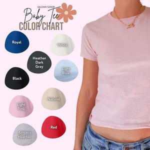 May include: A light pink baby tee shirt with a color chart showing various shirt colors, including royal blue, white, black, heather dark gray, light blue, light pink, natural, athletic heather, and red. The text "Baby Tee Color Chart" is displayed.