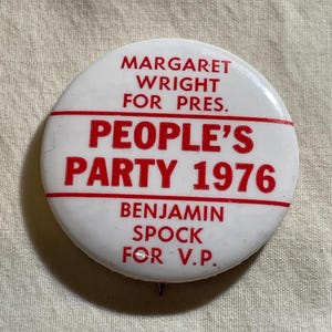 May include: A white political campaign button with red text. The button reads "MARGARET WRIGHT FOR PRES." above a red line, then "PEOPLE'S PARTY 1976", and "BENJAMIN SPOCK FOR V.P." below the line. The button has a pin on the back.
