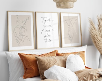 May include: Three framed art prints with line drawings and text. The left print features a face, the center print reads "Together is our favourite place to be," and the right print shows hands holding. The prints are above pillows.