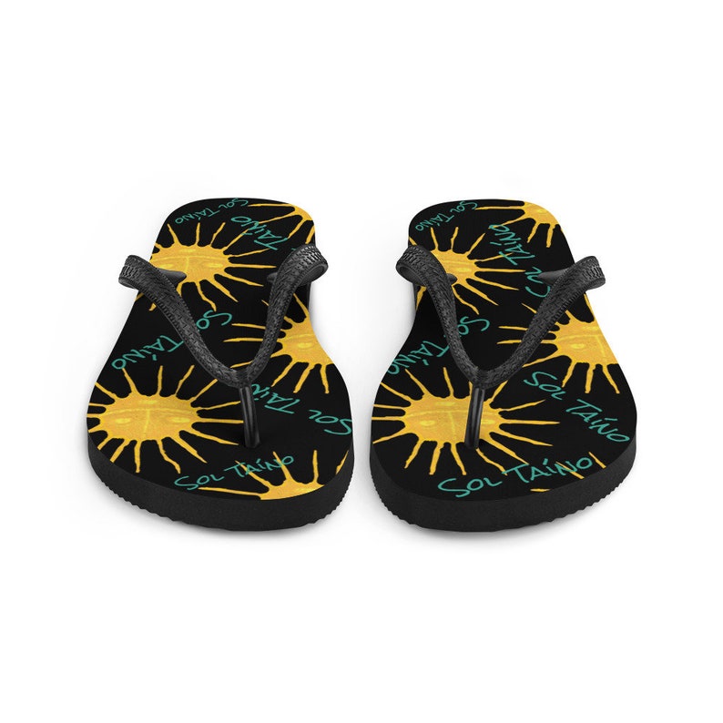 Black flipflops with Taino sun symbols and the words sol Taino in blue colors .Chancletas con sol Taino Arte original por Artista Puertorriquena.   #latinartwork #chancletas #buylatinartwork #blackflipflops