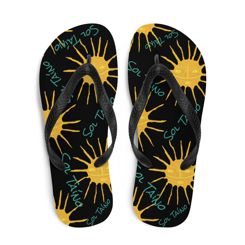 Black flipflops with Taino sun symbols and the words sol Taino in blue colors .Chancletas con sol Taino Arte original por Artista Puertorriquena.   #latinartwork #chancletas #buylatinartwork #blackflipflops