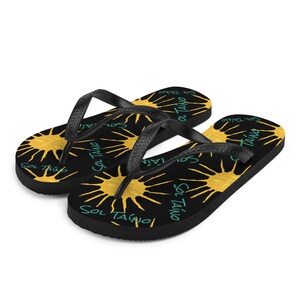 Black flipflops with Taino sun symbols and the words sol Taino in blue colors .Chancletas con sol Taino Arte original por Artista Puertorriquena.   #latinartwork #chancletas #buylatinartwork #blackflipflops |  summer havaianas