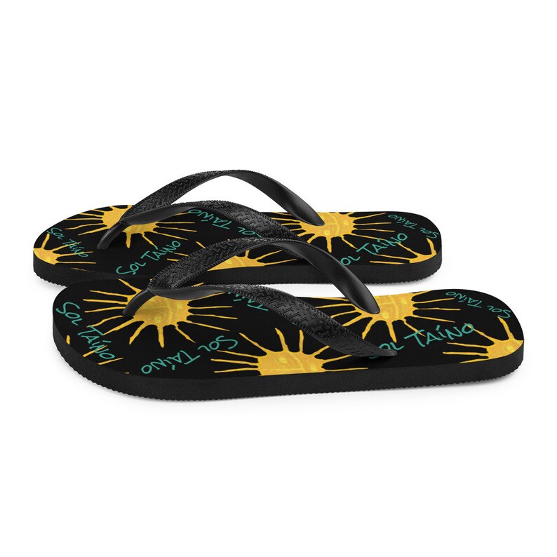 Black flipflops with Taino sun symbols and the words sol Taino in blue colors .Chancletas con sol Taino Arte original por Artista Puertorriquena.   #latinartwork #chancletas #buylatinartwork #blackflipflops