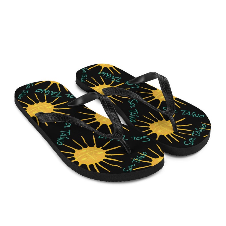Black flipflops with Taino sun symbols and the words sol Taino in blue colors .Chancletas con sol Taino Arte original por Artista Puertorriquena.   #latinartwork #chancletas #buylatinartwork #blackflipflops