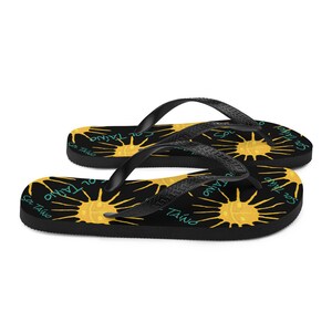 Black flipflops with Taino sun symbols and the words sol Taino in blue colors .Chancletas con sol Taino Arte original por Artista Puertorriquena.   #latinartwork #chancletas #buylatinartwork #blackflipflops