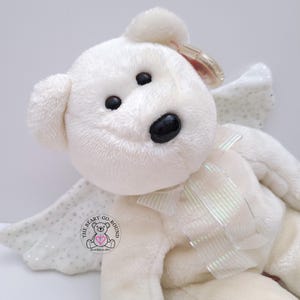 Vintage TY 2003 HERALD The Angel Beanie Buddy Bear
Measures approximately 13" in length (9" seated).  
Herald is preowned and in excellent clean condition.  He has a spot on his right foot, see pics.  Herald is off-white in color, so soft to the touch and has pellet-filled limbs/tush.  He has glittery wings and a beautiful matching ribbon.  Herald will make a lovely companion or gift to a loved one 💖.  Comes from a pet-free, smoke-free home.