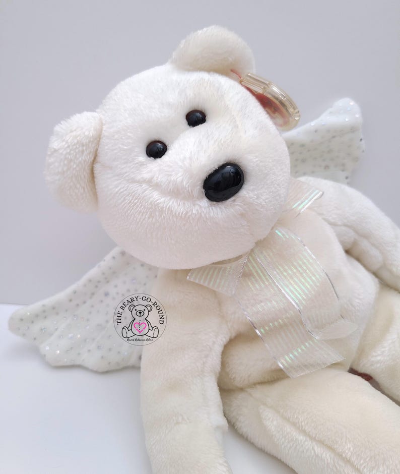 Vintage TY 2003 HERALD The Angel Beanie Buddy Bear
Measures approximately 13" in length (9" seated).  
Herald is preowned and in excellent clean condition.  He has a spot on his right foot, see pics.  Herald is off-white in color, so soft to the touch and has pellet-filled limbs/tush.  He has glittery wings and a beautiful matching ribbon.  Herald will make a lovely companion or gift to a loved one 💖.  Comes from a pet-free, smoke-free home.