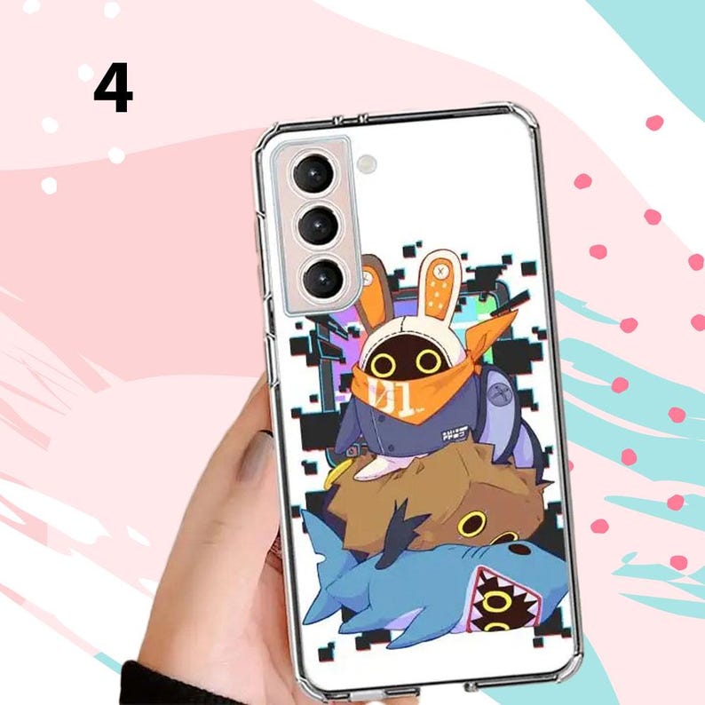 Puede incluir: Funda de tel&eacute;fono transparente con dise&ntilde;o de dibujos animados. El dise&ntilde;o incluye un personaje de conejo con orejas y bufanda naranja, un personaje marr&oacute;n y un tibur&oacute;n azul. La funda del tel&eacute;fono est&aacute; sujeta por una mano.