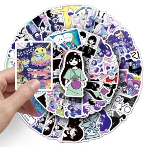 Puede incluir: Una colecci&oacute;n de pegatinas coloridas con varias ilustraciones de estilo anime. Una mano sostiene una pegatina, mostrando una escena vibrante con un personaje parecido a un gato. Las pegatinas incluyen personajes, paisajes y texto, con una variedad de colores y dise&ntilde;os.