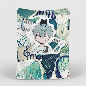 May include: A teal and white blanket with a collage of anime-style illustrations. The design includes images of a person with light blue hair, musical notes, and a guitar. The overall theme is music and anime.