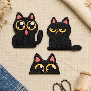 Puede incluir: Tres parches bordados de gatos negros. El gato de arriba a la izquierda tiene ojos grandes y abiertos con la boca abierta. El gato de arriba a la derecha tiene ojos amarillos estrechos y expresión seria. El gato de abajo muestra solo la cabeza.