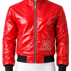 Può includere: Giacca bomber rossa lucida con zip, polsini e orlo neri. La giacca ha un colletto rialzato e un logo del marchio sul petto. Il tessuto è lucido e liscio.