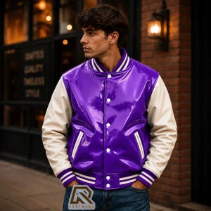 May include: A varsity jacket featuring a glossy purple body and contrasting off-white sleeves. The jacket includes a ribbed collar, cuffs, and hem with white stripes, a front snap-button closure, and two side pockets with white trim details.
