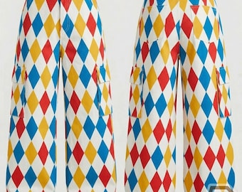 Könnte beinhalten: Hoch taillierte Cargohose mit einem sich wiederholenden Rautenmuster in leuchtendem Rot, Blau und Gelb auf weißem Grund. Die Hose verfügt über seitliche Cargotaschen, einen Knopfverschluss und ein weites Bein, abgebildet von vorne und hinten.