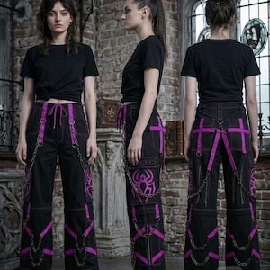 May include: Black cargo pants with purple accents, straps, and chains. The pants feature a spider web design on the pockets and are paired with a black t-shirt. The style is edgy and alternative.