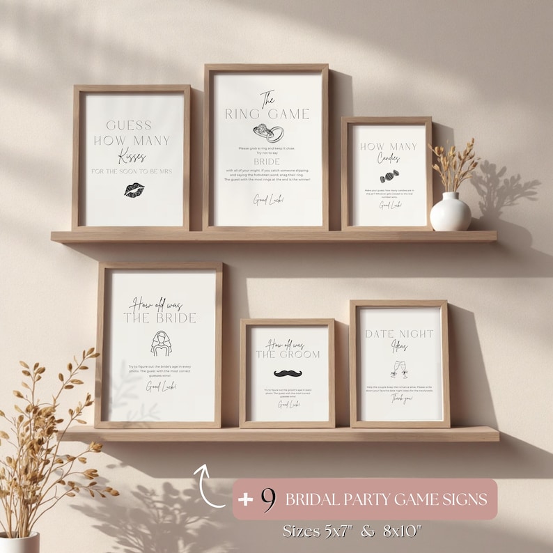 May include: A collection of framed bridal party game signs in various sizes. The signs feature black text on a white background with simple illustrations. Games include "Guess How Many Kisses" and "The Ring Game."