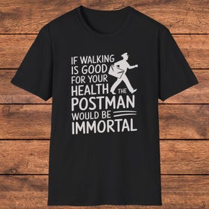 May include: A black short-sleeved t-shirt featuring white text that reads: IF WALKING IS GOOD FOR YOUR HEALTH THE POSTMAN WOULD BE IMMORTAL. The design includes a white graphic silhouette of a postman carrying a mail bag while walking.