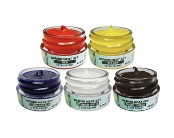 May include: Five small jars of paint, each with a different color: red, yellow, blue, white, and brown. The jars are labeled with the text "Gemini Heat Set" and the color of the paint. Each jar has a label that says "Extra Creamy".