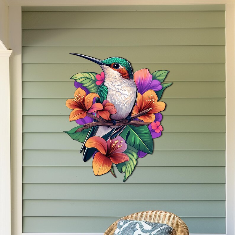 May include: A colourful hummingbird with green and white feathers perched on a branch with pink, orange and purple flowers. The hummingbird is surrounded by green leaves.